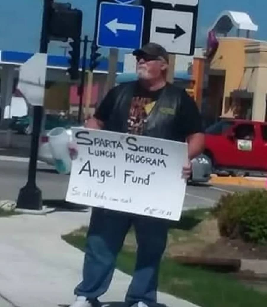 John Harrison collecting donations near the Walgreens corner in Sparta while holding his Angel Fund sign