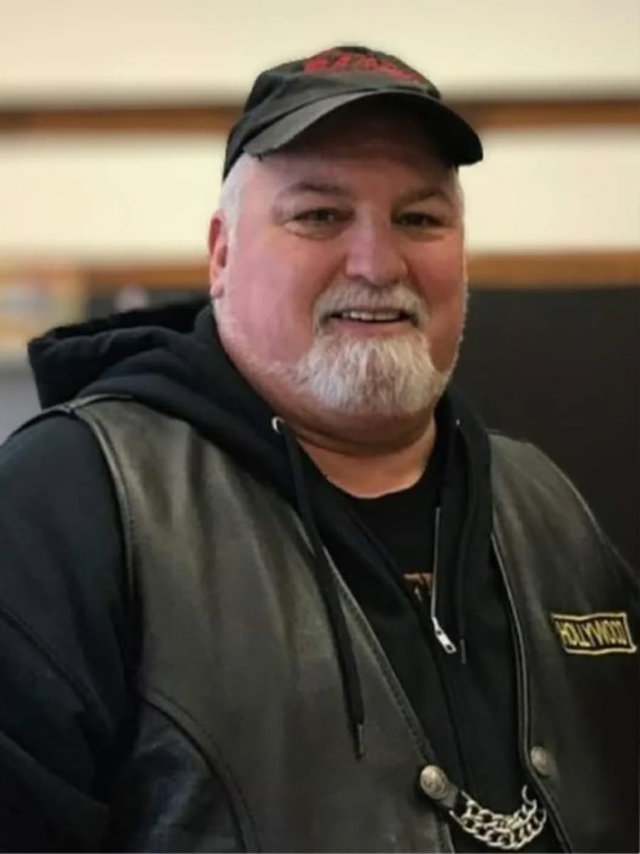 John Harrison smiling while wearing his Faith Riders vest and hat